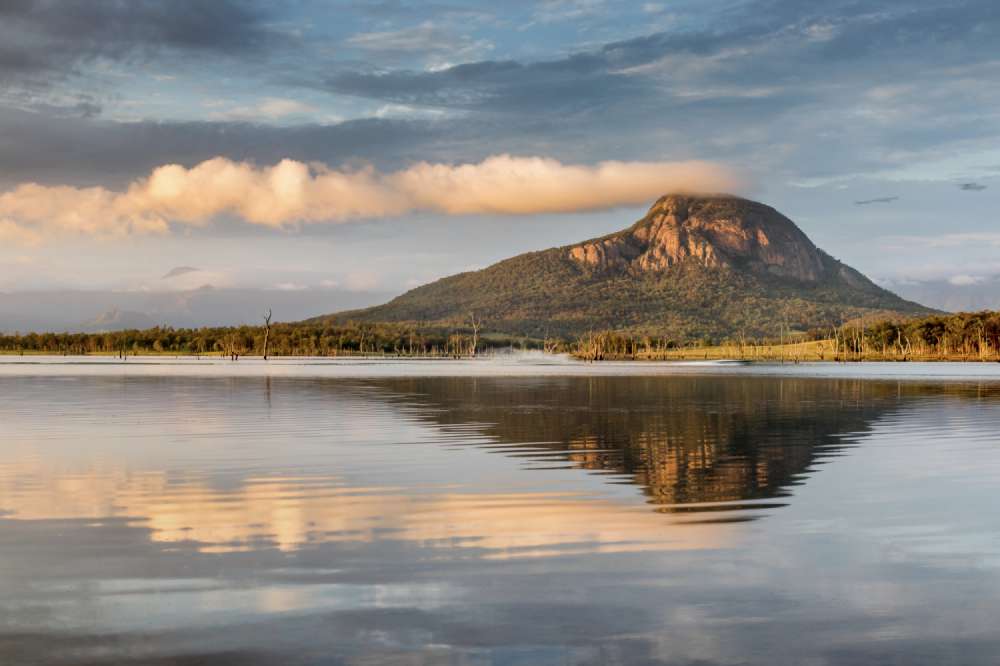 Sunrise of Lake Moogerah, looking towards Mount Greville. The first speedboat breaks the stillness of the lake.