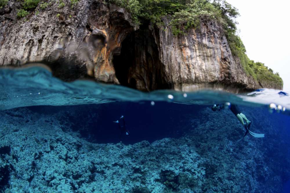 Over-under Split Shot of Limestone Cave Entrance with Turquoise Water